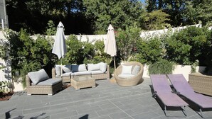 An outdoor patio with wicker furniture, including a sofa, a round chair, and two lounge chairs. - Quiet country house, swimming pool, ideal for families - Aix en Provence (Aix-en-Provence)
