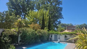 A swimming pool surrounded by lush greenery and a white building with a tiled roof. - Quiet country house, swimming pool, ideal for families - Aix en Provence (Aix-en-Provence)