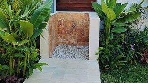 A spa area with a wooden door, a stone bench, and lush greenery. - 2BR Pool Villa-Twin Flower (Banjar)