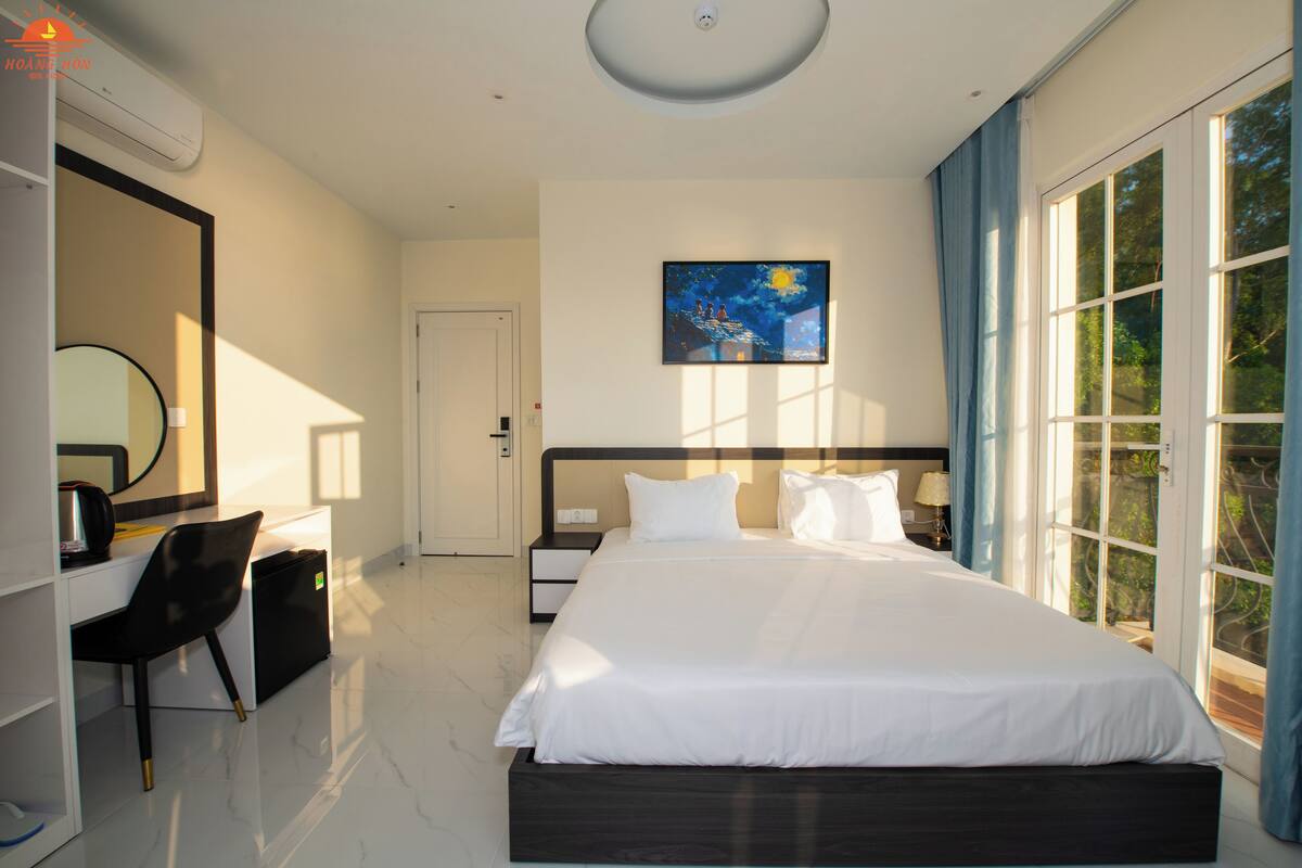 Une chambre à coucher moderne avec un grand lit, un bureau et une chaise.
