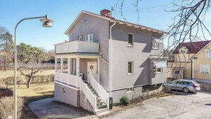 A two-story house with a balcony, a front door, and a car parked in the driveway. - Room-bed & Breakfast in Stockholm (Bromma)