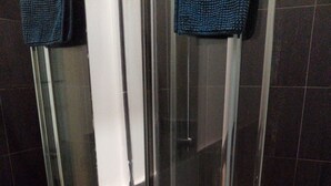 A bathroom with a white sink, a mirror, and a glass shower enclosure.