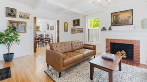 Un salon spacieux avec un canapé en cuir marron, une table basse et une cheminée.
