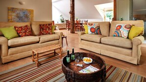 A spacious living area with two sofas, a coffee table, and a dining table. - Loft in Cotswolds With Pool & Scenic Gardens (Chipping Norton)