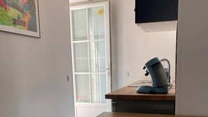 A hallway with a wooden table, a blue chair, and a map on the wall.
