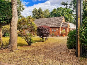 A brick house with a tiled roof, surrounded by a garden with a gravel driveway. - 2 bedroom accommodation in Smallburgh (Smallburgh)