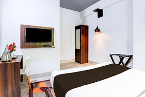 A hotel room with a bed, a desk with a lamp, a TV, and a wardrobe. - Classic Chandrasekharpur (Bhubaneshwar)