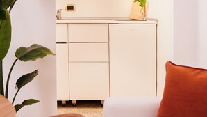 Un espacio habitable compacto con kitchenette, comedor y zona de estar.