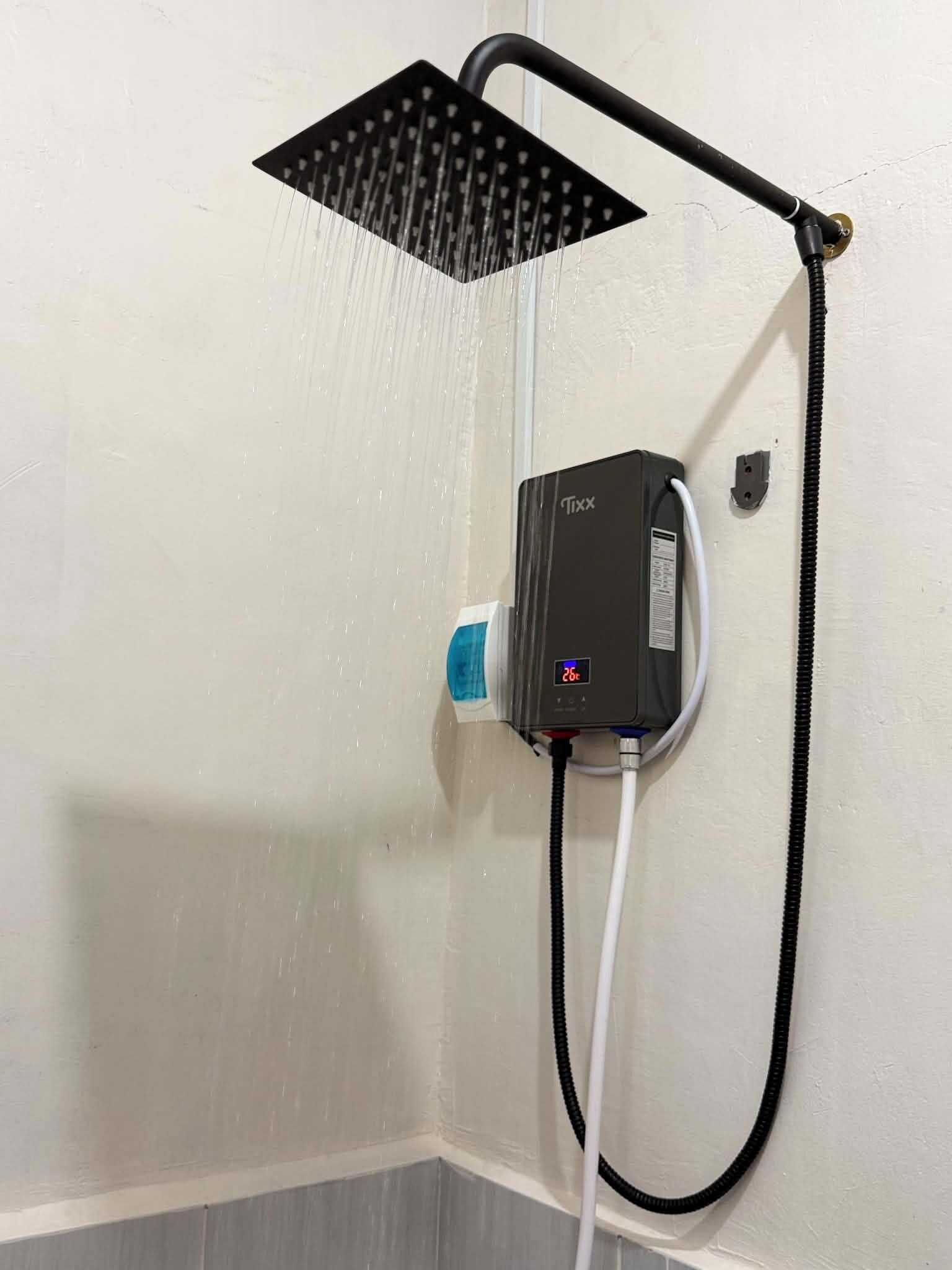 Eine Dusche mit Handbrause und Armaturen an der Wand.