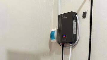 Eine Dusche mit Handbrause und Armaturen an der Wand.