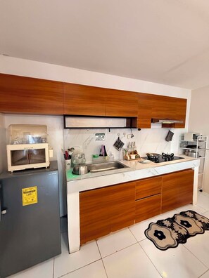 Une cuisine moderne avec des meubles en bois, une cuisinière encastrée et un réfrigérateur.