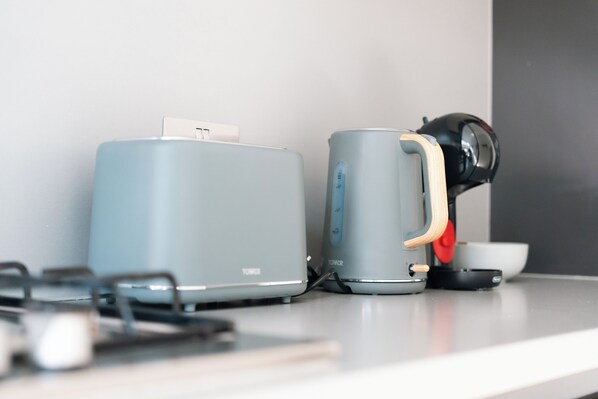 A kitchen with a toaster and a coffee maker on the counter.