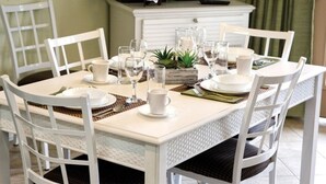 A dining table set with plates, glasses, and a small plant centerpiece.
