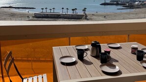 A table set for two with a view of the beach and ocean.
