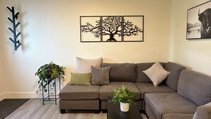 Un soggiorno moderno con un divano componibile, un tavolino da caffè e decorazioni a parete.