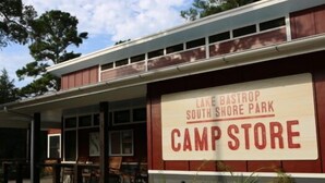 Een gebouw met een bord waarop staat: Lake Bastian South Shore Park Camp Store.