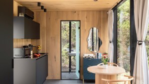 Una cucina moderna con forno a microonde integrato, lavello e zona pranzo con tavolo rotondo e sedie.