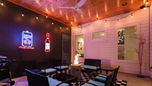 An outdoor seating area with wicker furniture and a checkered floor. - Modern ATX Mansion Walk to 6th Street (Austin)