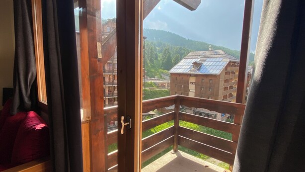 A wooden balcony with a view of a mountainous landscape and buildings. - Duplex 6 pers at the foot of the slopes Comfort, charm & mountain view Ski in & out (Risoul)