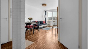 A modern apartment with a dining area, a sofa, and a view of the city.