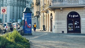 A street with historic buildings, a café named 'Tygiel', and a blue sign with 'Morszczynowski' and '20m' visible. - The Vinci Residence • Premium Studio | Kraków Old Town (Kraków)