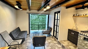 A modern kitchen with a gas stove, a sink, and a dining area with a sofa and chairs. - EL MIRADOR, Casa EA Oaxaca, Historic Center, Terrace and Mountain View. (OAXACA DE JUAREZ)
