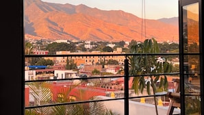 A view from a window overlooking a town with mountains in the background. - EL MIRADOR, Casa EA Oaxaca, Historic Center, Terrace and Mountain View. (OAXACA DE JUAREZ)