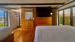 A modern bedroom with a wooden floor, a bed, a wooden wardrobe, a large mirror, and a TV. - EL MIRADOR, Casa EA Oaxaca, Historic Center, Terrace and Mountain View. (OAXACA DE JUAREZ)