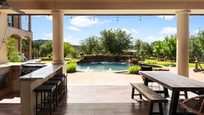 An outdoor patio with a pool, bar area, and seating.