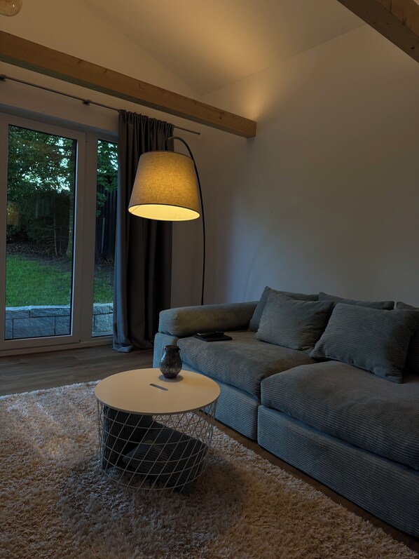 A modern living room with a grey sofa, a round coffee table, and a floor lamp.