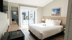 Una habitación de hotel moderna con una cama grande, un escritorio y una televisión.