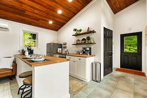 Enjoy cooking in this well-equipped kitchen with a central island, sink, refrigerator, and coffee machine.