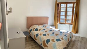 A bedroom with a bed, a desk, and a window. - House in the heart of a village (Sainte-Foy-la-Grande)