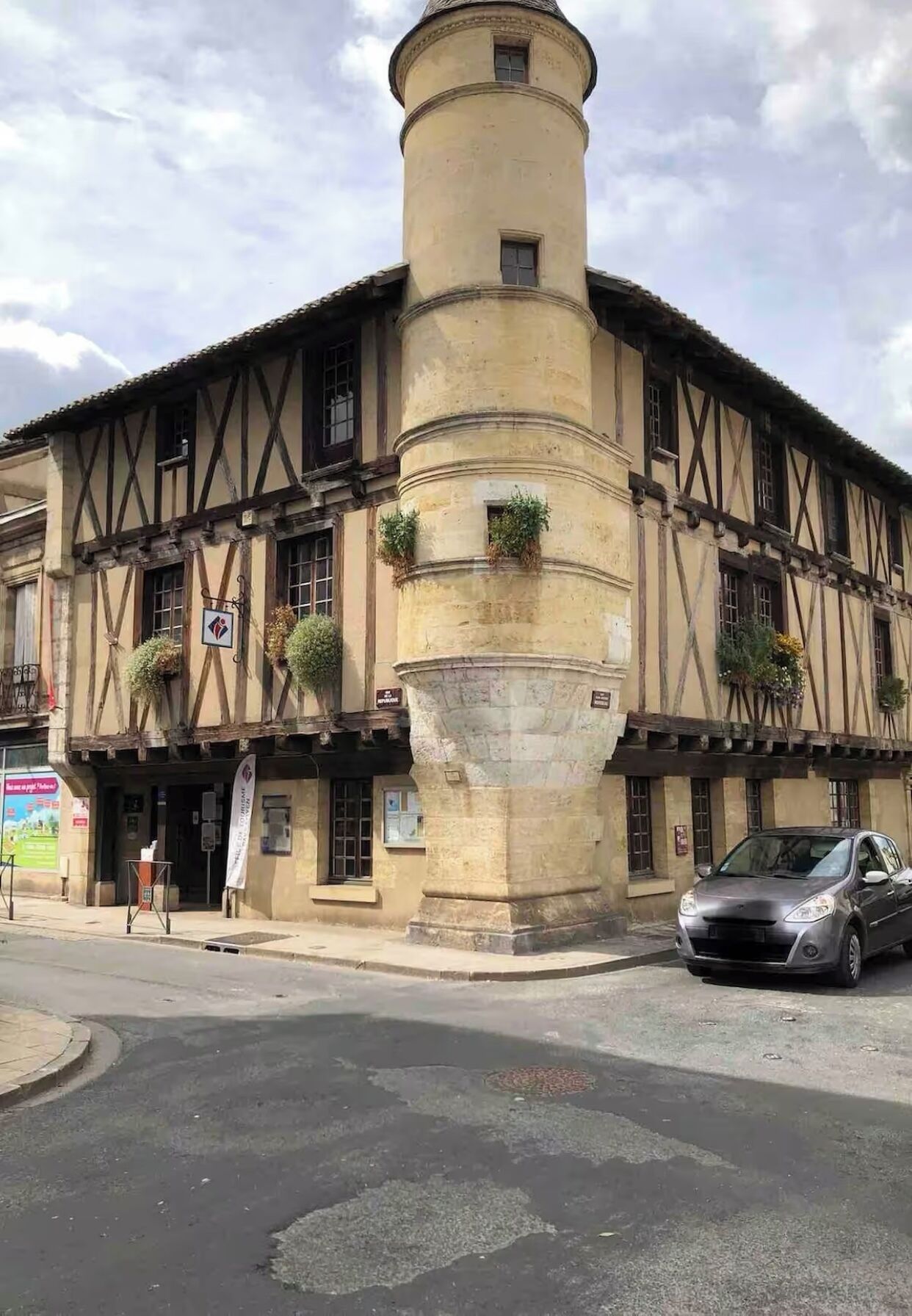 A historic building with a central tower, a traditional facade with timber framing, and a street-level entrance.