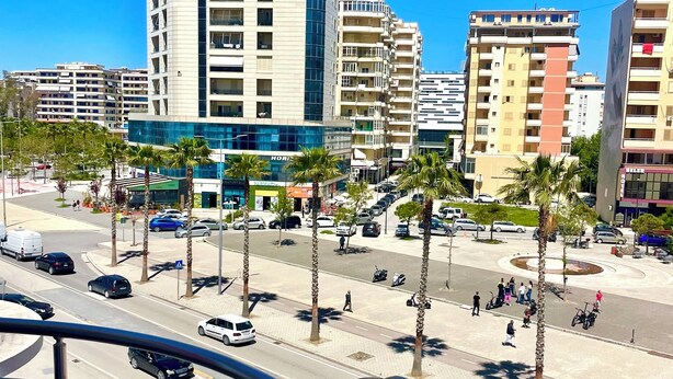 A city street with tall buildings, palm trees, and cars. - Seaside and spacious Apartment for up to 7 people (Vlorë)