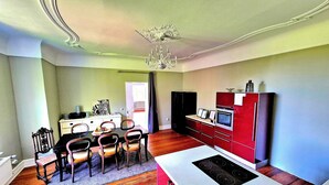 Een compacte keuken met een centraal eiland, een eethoek met tafel en stoelen, en een koelkast.