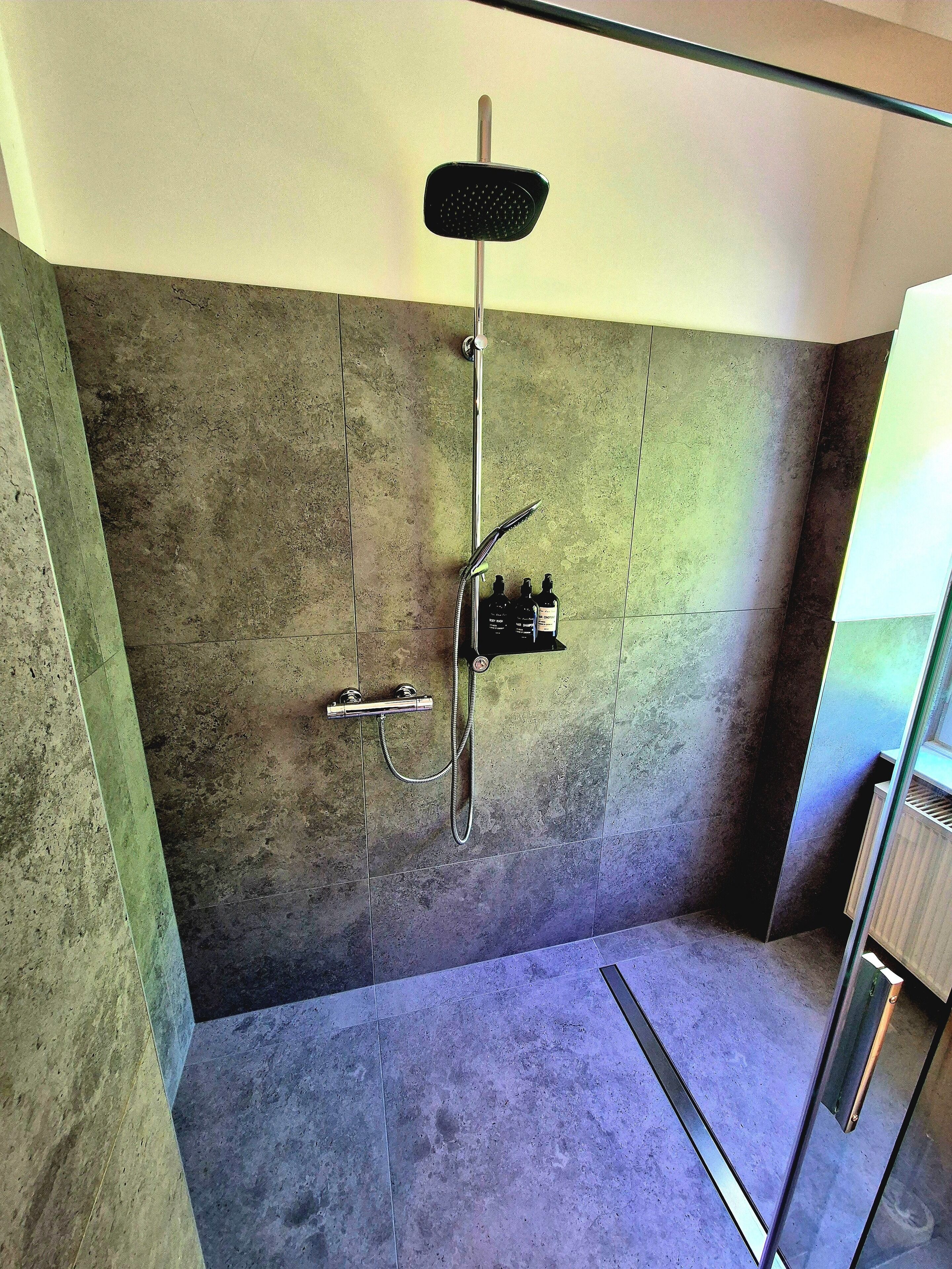 Eine Dusche mit drei Handbrausen.
