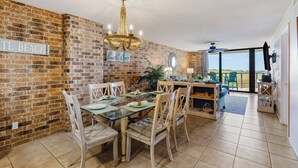 A dining area with a brick wall, a chandelier, and a sign that reads "TE BEACH".