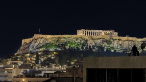 A rooftop terrace with a view of a historic building, a pool area with a bottle of wine, two glasses, and a candle. - Acropolis Dream with Plunge Pool (Athina)