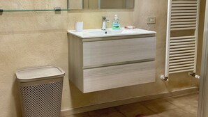 A bathroom with a white sink, mirror, and a towel rack.