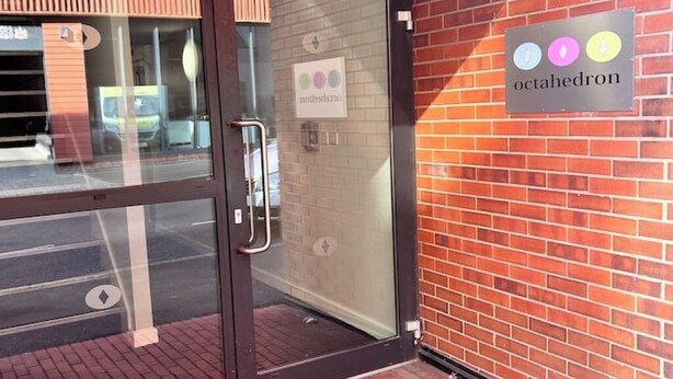 Un ingresso con porta in vetro a un edificio con un cartello che riporta 