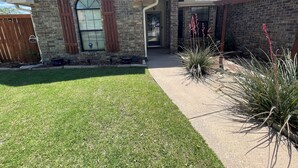 A two-story house with a brick facade, a front porch, and a well-maintained lawn. - Relaxation, Comfort & Style (Lawton)