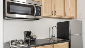 A modern kitchen with a stainless steel microwave, a coffee maker, a sink, and a refrigerator. - Across from Leech Lake! (Walker)