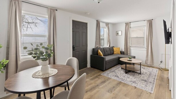 A modern living room with a sofa, a coffee table, and a dining table with chairs. - Across from Leech Lake! (Walker)