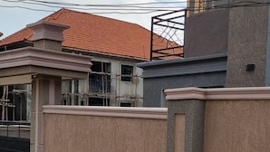 A residential building with a modern design, featuring a large wall with a geometric pattern and a balcony with a metal railing. - Abba nest, Enjoy a home away from home (Kampala)