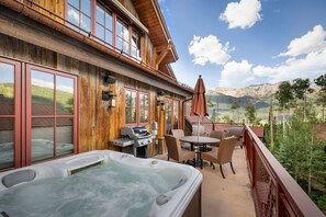 A wooden building with a hot tub, outdoor seating, and a view of mountains. - The Veranda at Trails Edge - penthouse views! (Mountain Village)