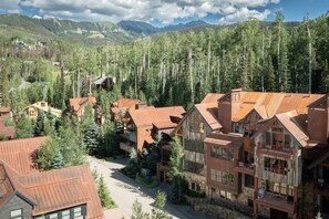 A resort with multiple wooden buildings surrounded by dense forest and mountains. - The Veranda at Trails Edge - penthouse views! (Mountain Village)