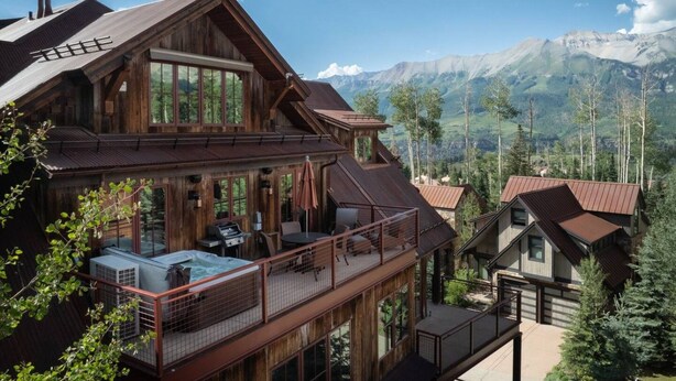 A large wooden cabin with multiple levels, outdoor seating, and a view of mountains. - The Veranda at Trails Edge - penthouse views! (Mountain Village)