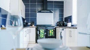Une cuisine moderne avec des armoires blanches, une cuisinière en acier inoxydable et un lave-vaisselle.