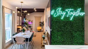 Ein moderner Essbereich mit einem Marmortisch, Stühlen und einem Neon-Schild mit der Aufschrift '#Stay Together'.